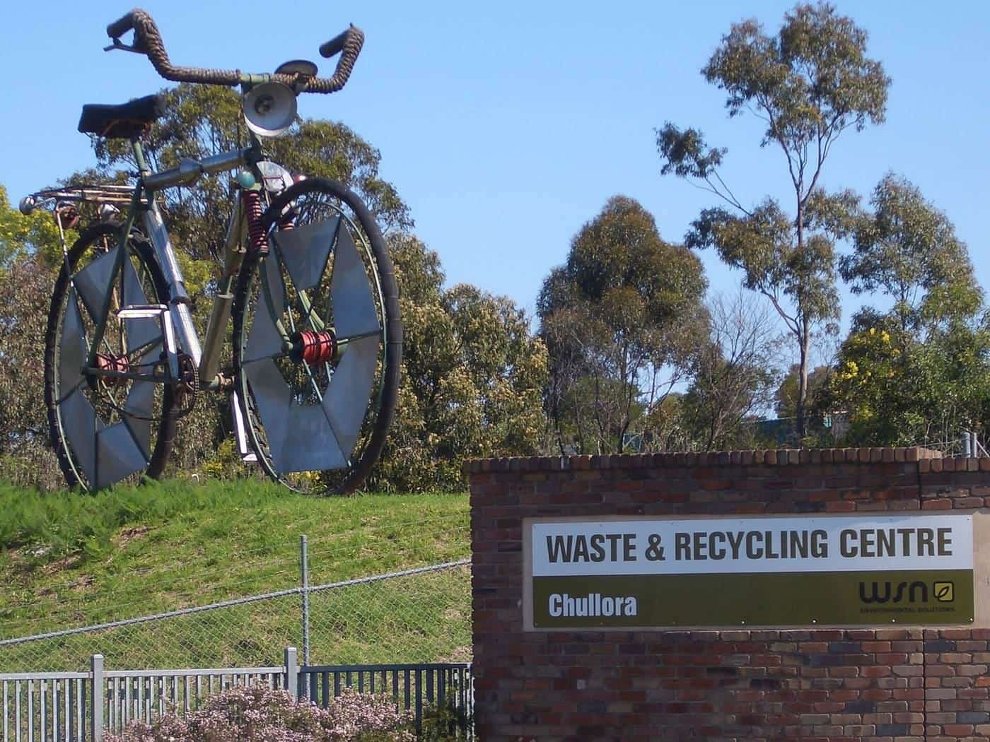 The entrance sign of a waste and recycling centre in Sydney with a giant bicycle sculpture